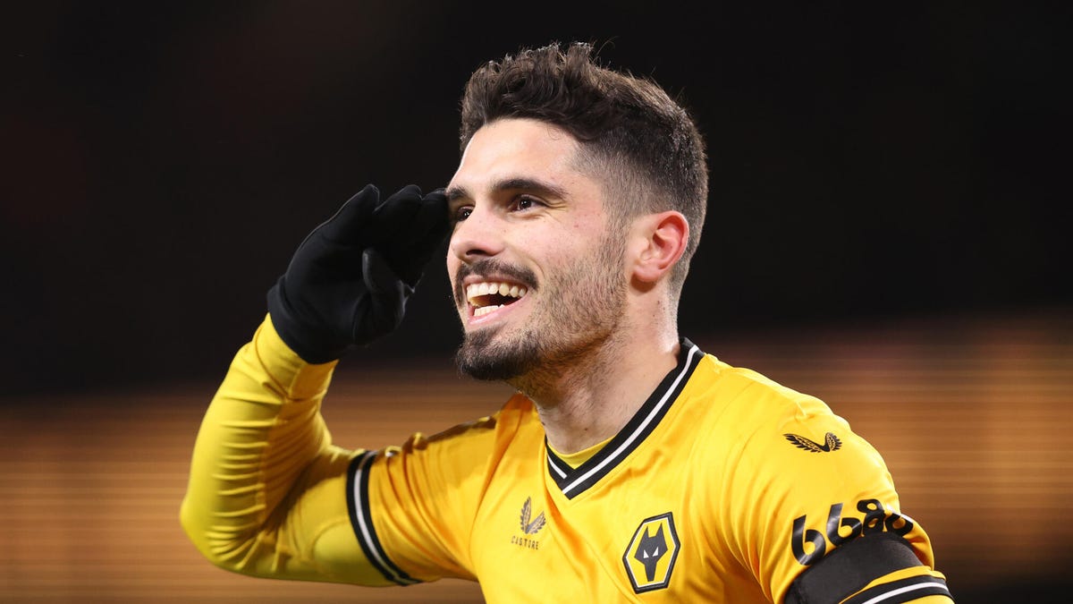 Pedro Neto of Wolverhampton Wanderers, smiling, celebrating, saluting with his right hand.