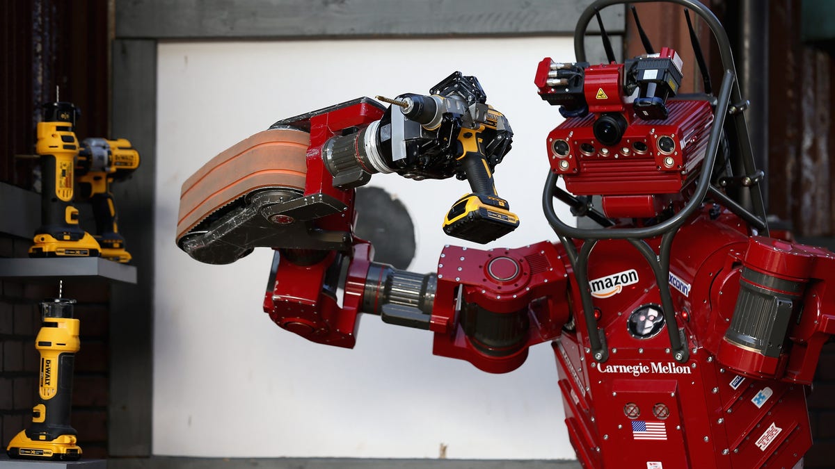 red AI robot holding a drill