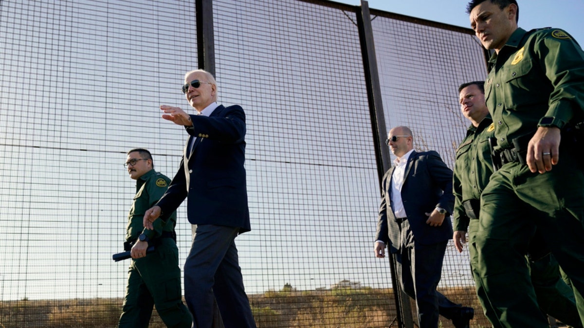 President Joe Biden walks along a stretch of the U.S.-Mexico border