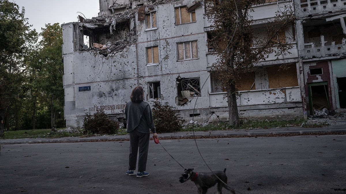 A woman, demolished building in Ukraine