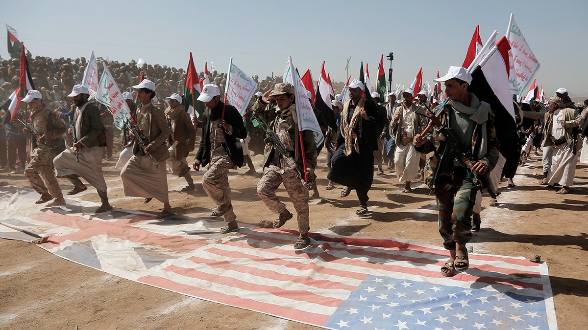 Houthi militants stomping on US, UK flags