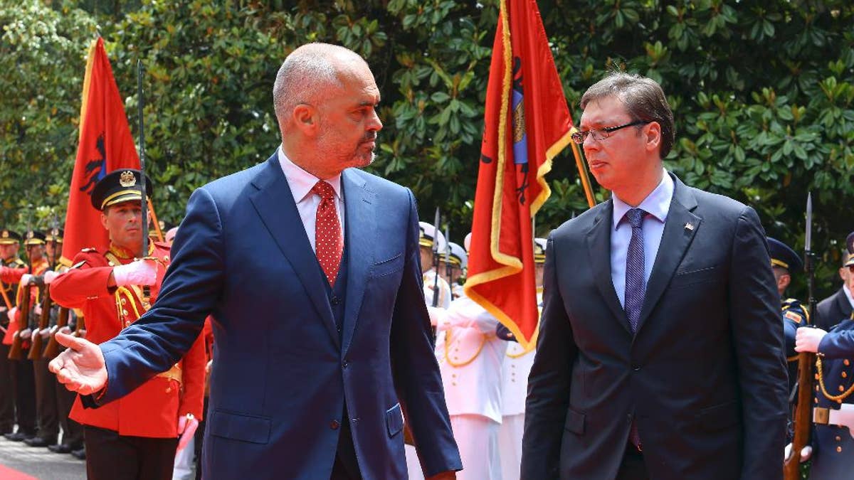 Albanian Prime Minister Edi Rama, left, welcomes Serbian Prime Minister Aleksandar Vucic, the first Serbian leader to visit the nation after a troubled past, as they walk along the red carpet at the Palace of Brigades, in Tirana, Albania, Wednesday, May 27, 2015. The visit is held under tight security measures with some 1,300 policemen guarding capital Tirana, police and army helicopters hovering over the air and streets downtown Tirana blocked. Vucic’s arrival on Wednesday follows Albanian Prime Minister Edi Rama’s visit to Belgrade in November, the first by an Albanian head of government to Serbia in 68 years. (AP Photo/Hektor Pustina)