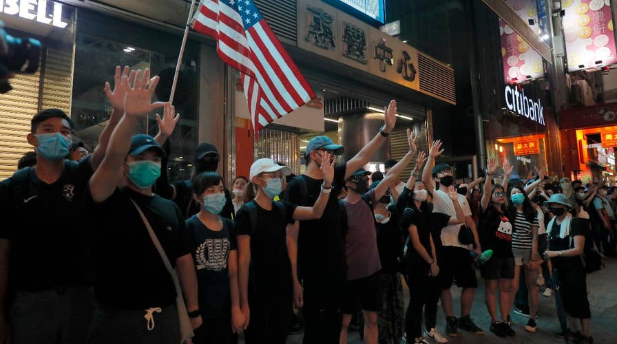 Hong Kong demonstrators wear face masks in defiance of ban