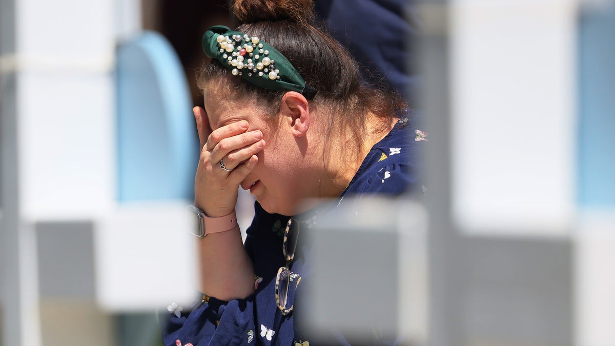 A woman cries before a memorial