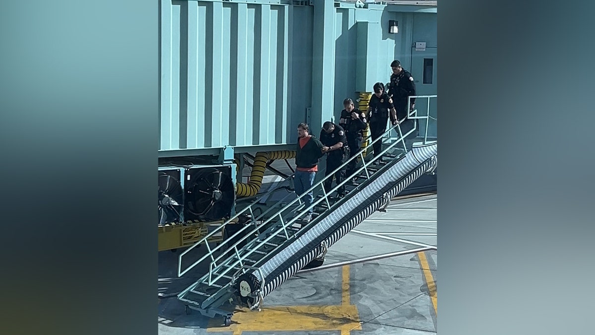 Passenger escorted off plane