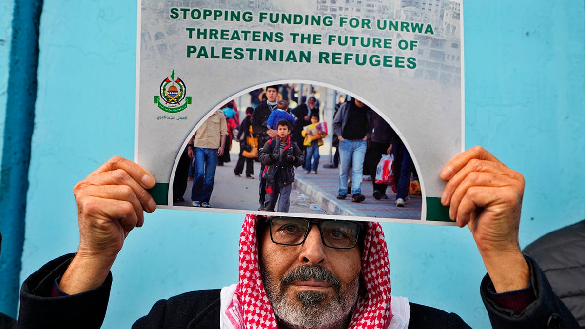 Protester holds sign supporting UNRWA funding