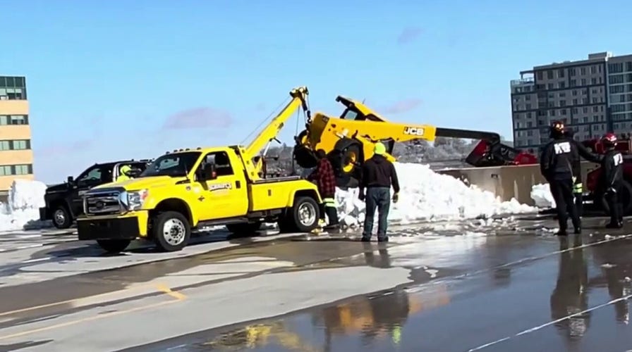 Heavy equipment flips over side of Wisconsin parking garage