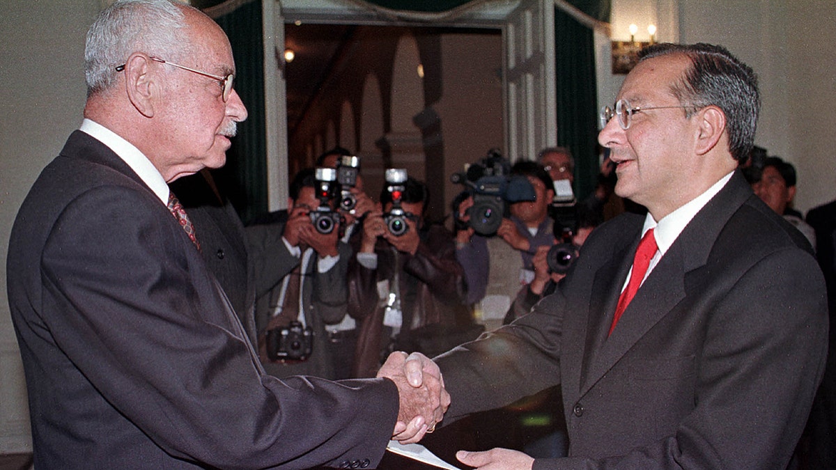 Bolivian President Hugo Banzer shakes hands with Victor Manuel Rocha