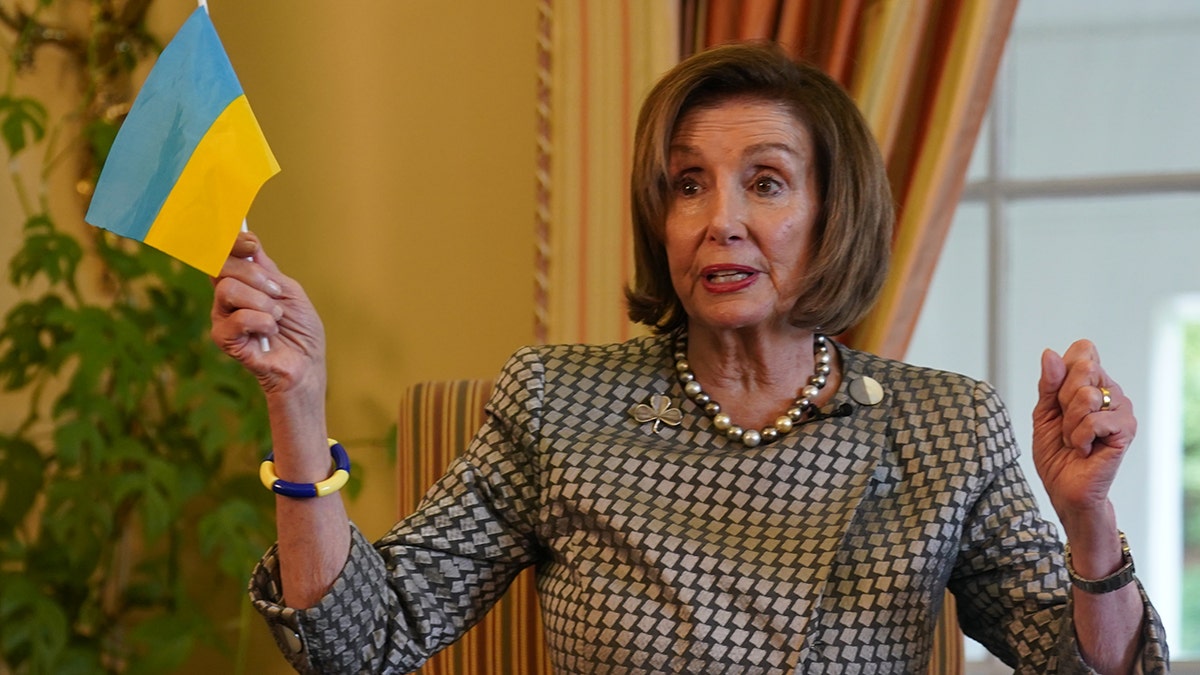 Nancy Pelosi holding a Ukrainian flag