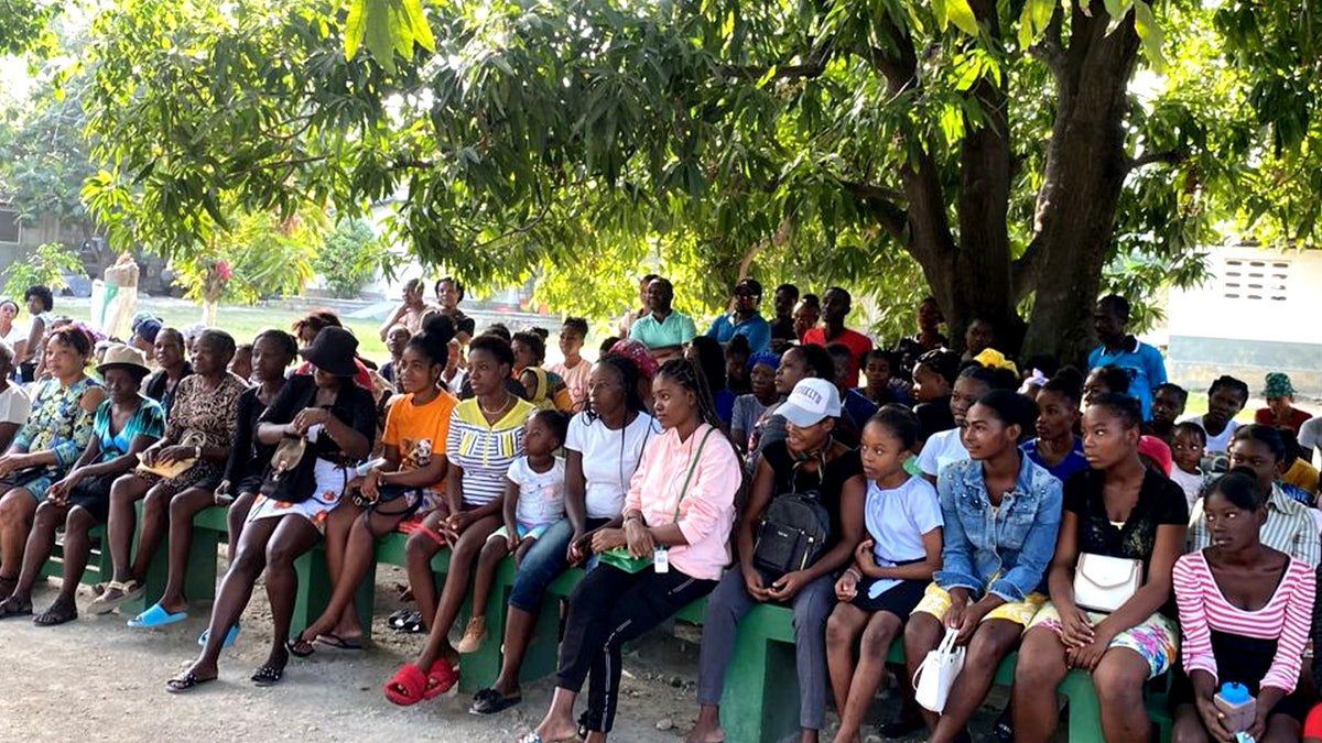 Haitians sit outside