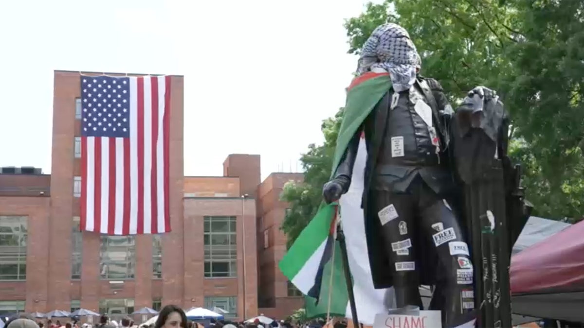 A large American flag is unfurled at George Washington University