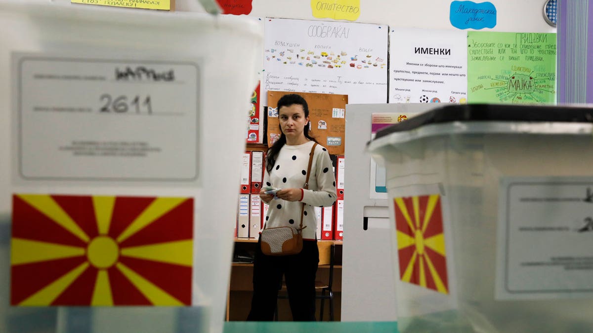 A woman casts her ballots for the parliamentary election and the presidential runoff in North Macedonia