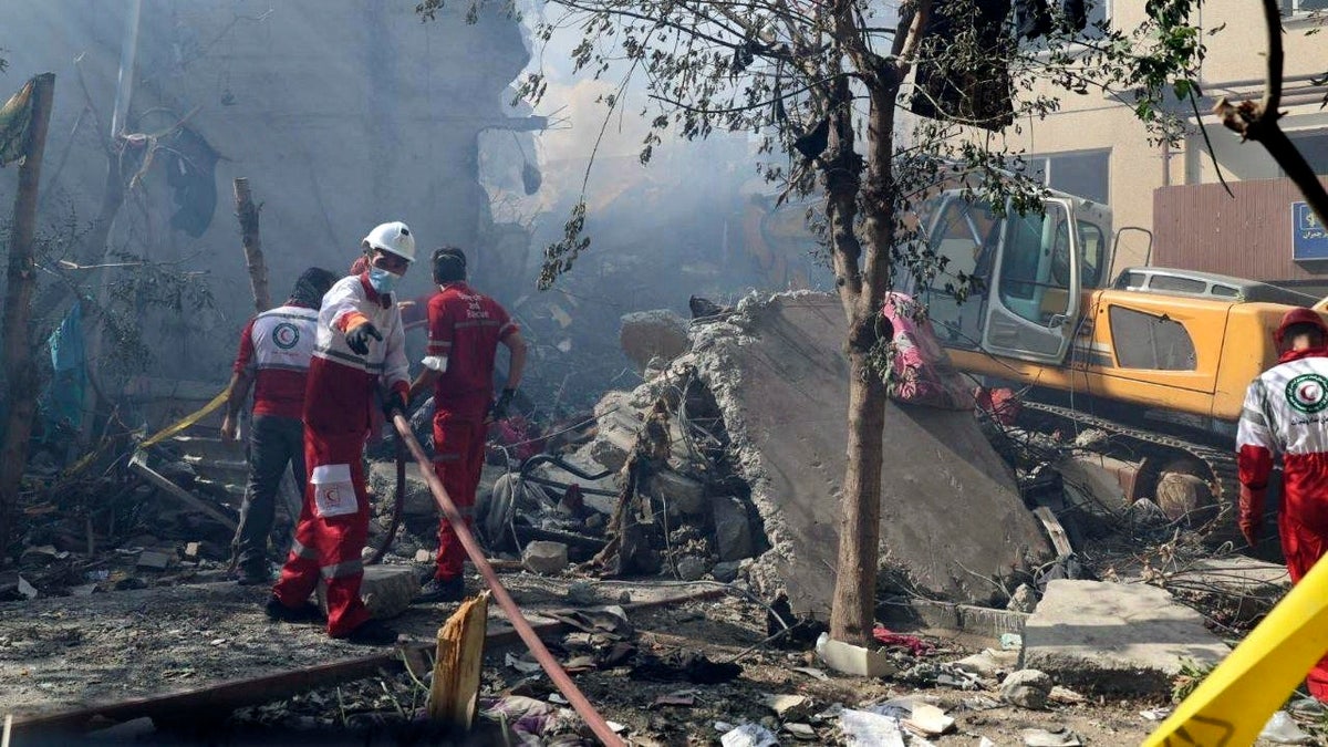 Rescuers work at the scene of an explosion after an Israeli strike in Tehran, Iran, on Friday, June 13, 2025.