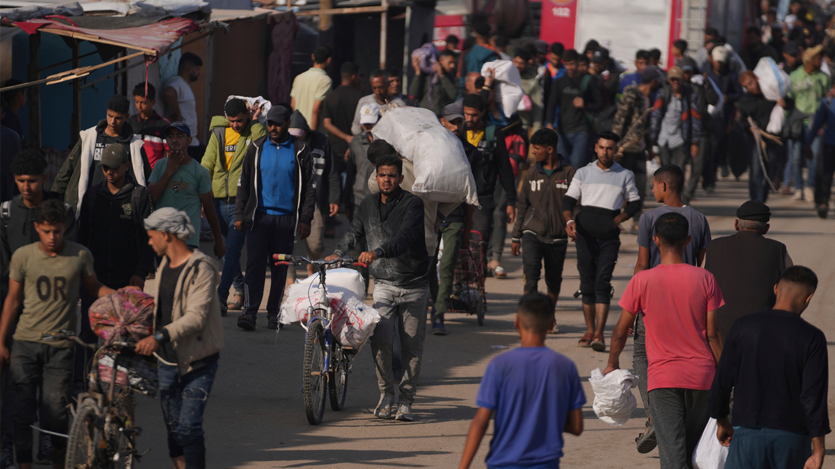 Palestinians carry bags containing food and humanitarian aid packages