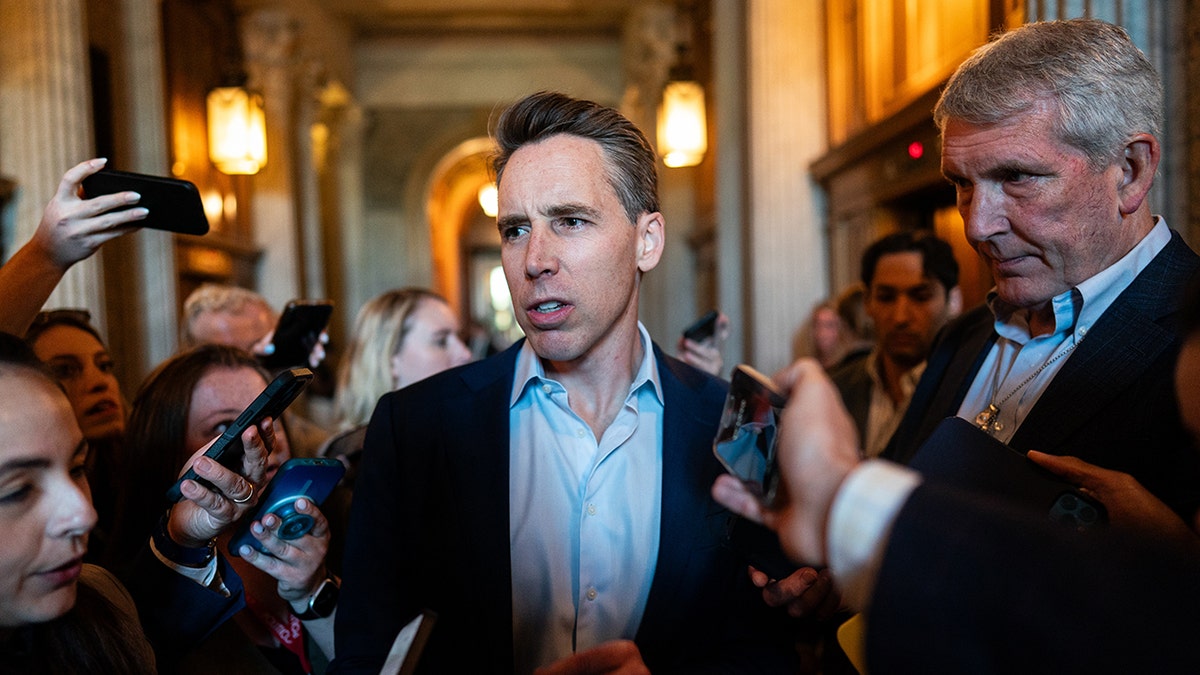Hawley surrounded by reporters in Capitol hallway