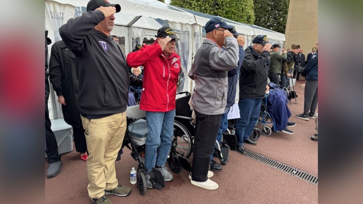 Veterans saluting at a D-Day celebration parade