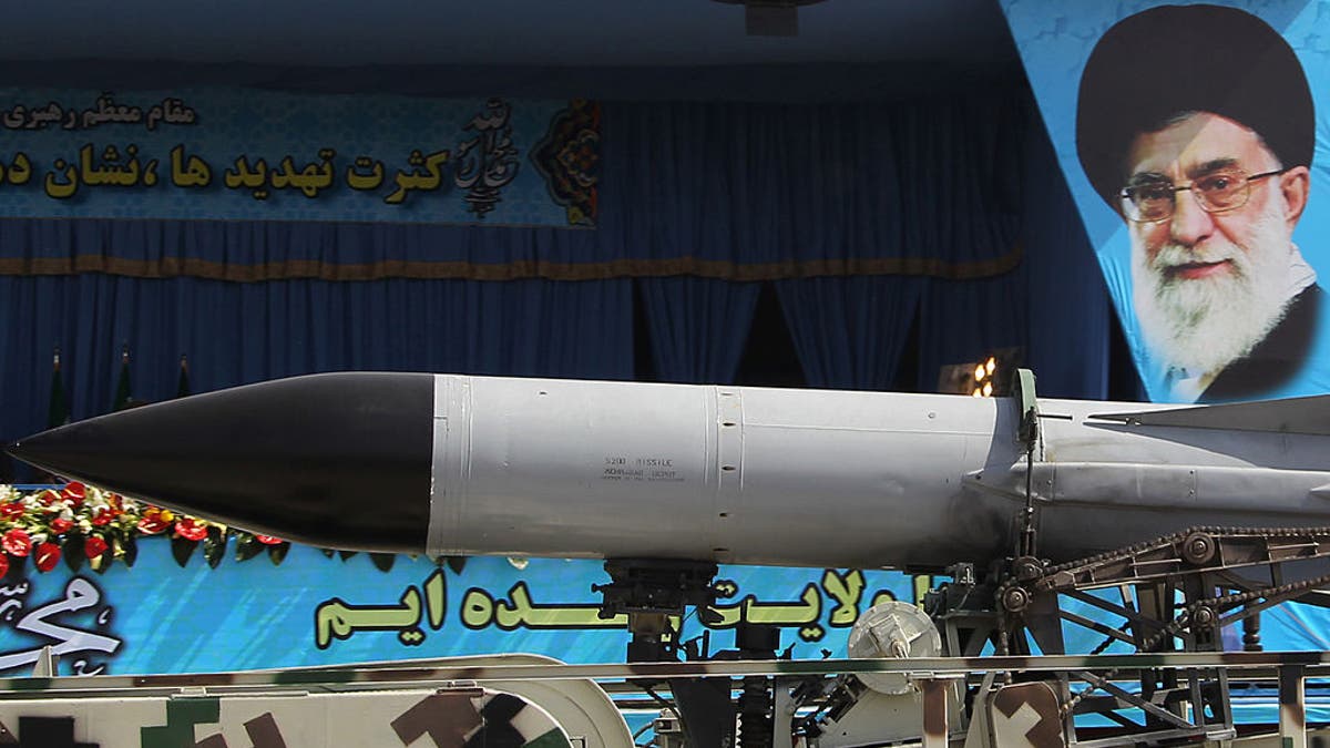 A military truck carries a missile past a portrait of Iran's Supreme Leader Ayatollah Ali Khamenei during an annual military parade.  
