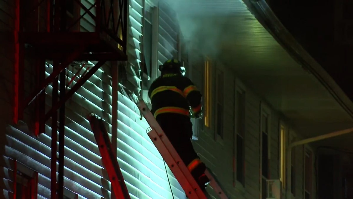 firefighter climbs up ladder to window