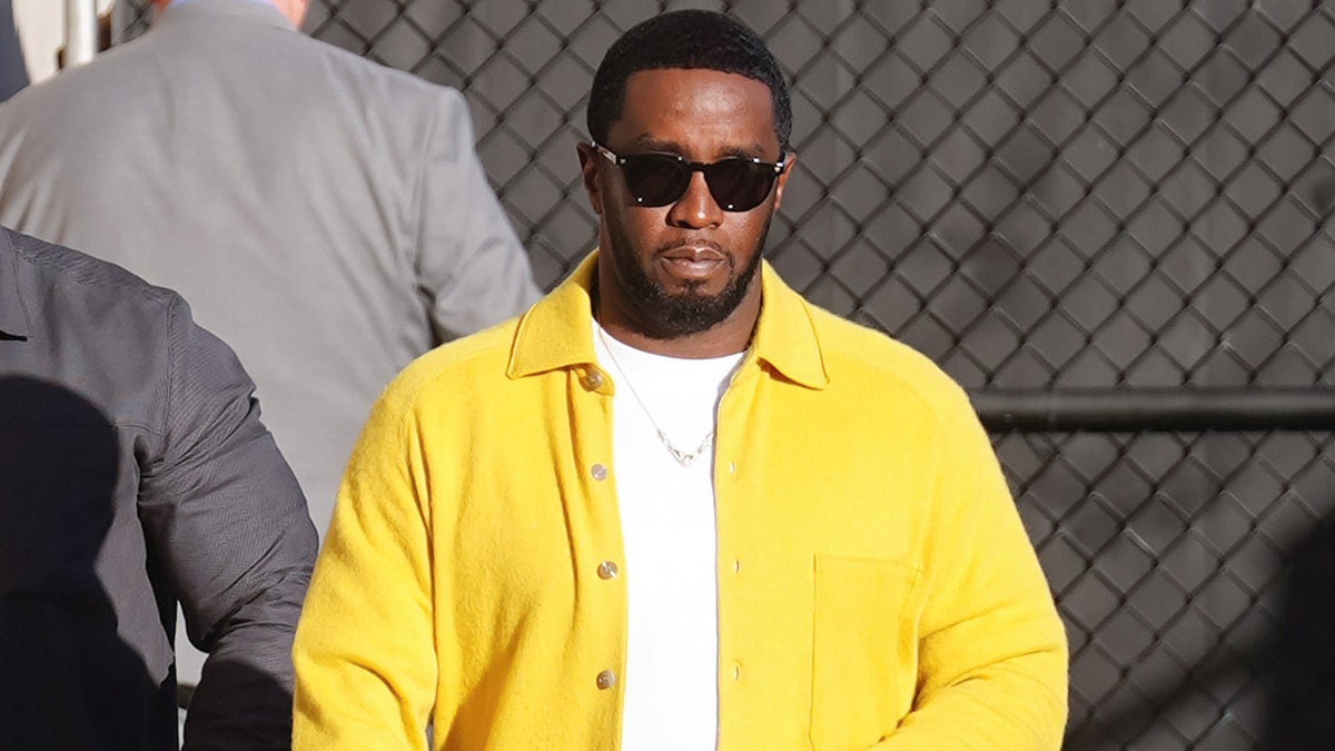 Diddy wearing a yellow button up over a white shirt