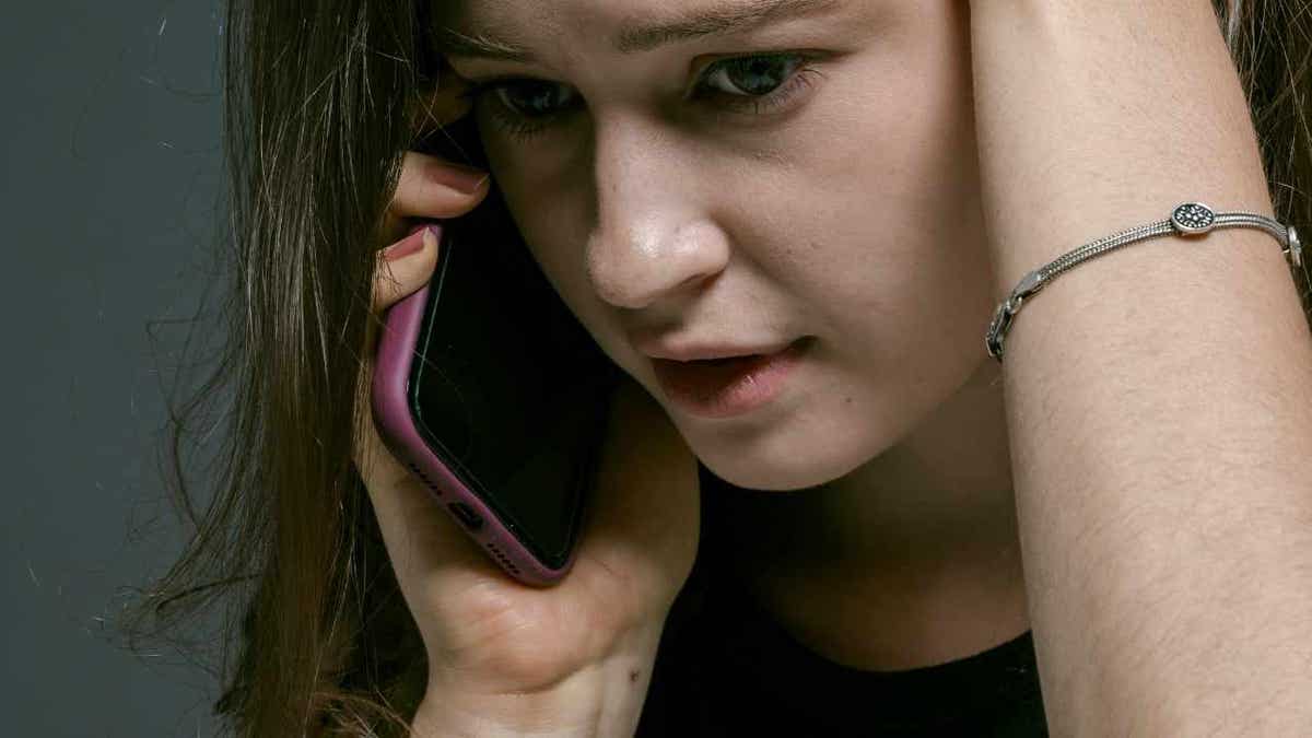 A woman receiving a fake scam phone call.