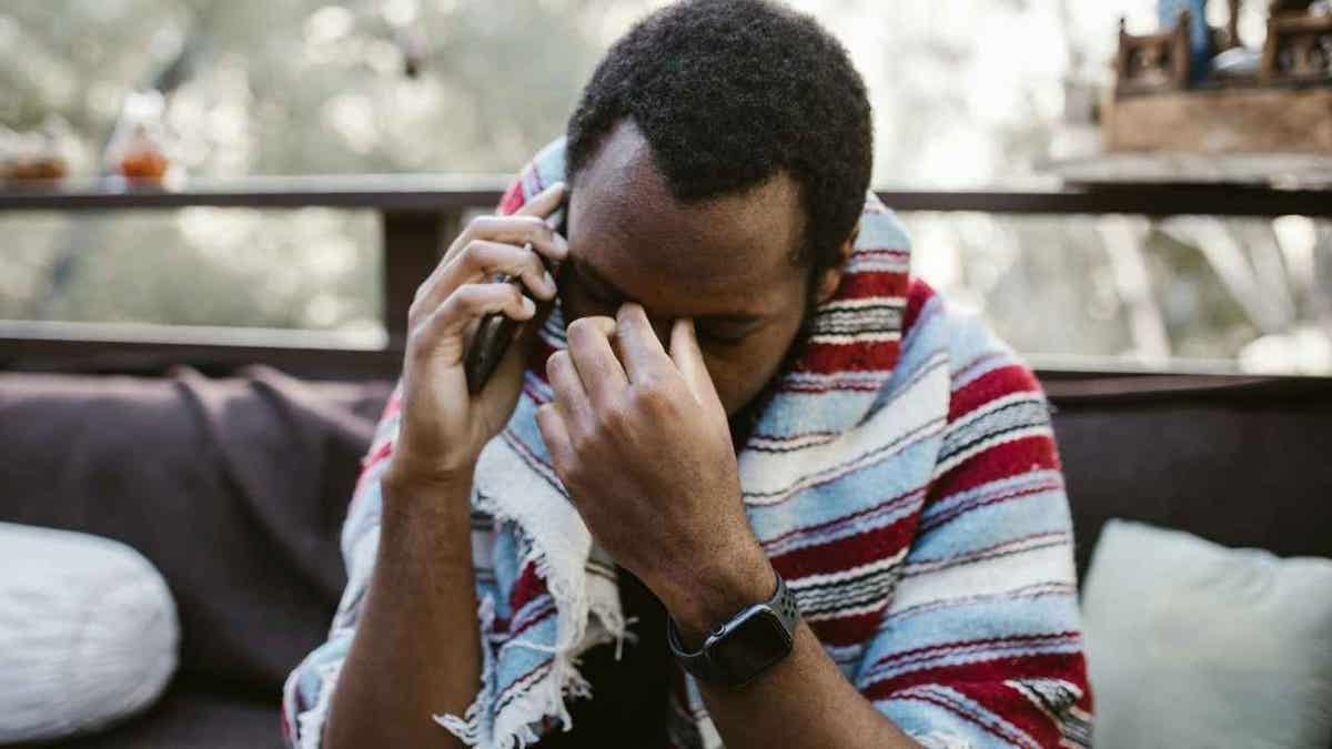 A man receiving a fake scam phone call.