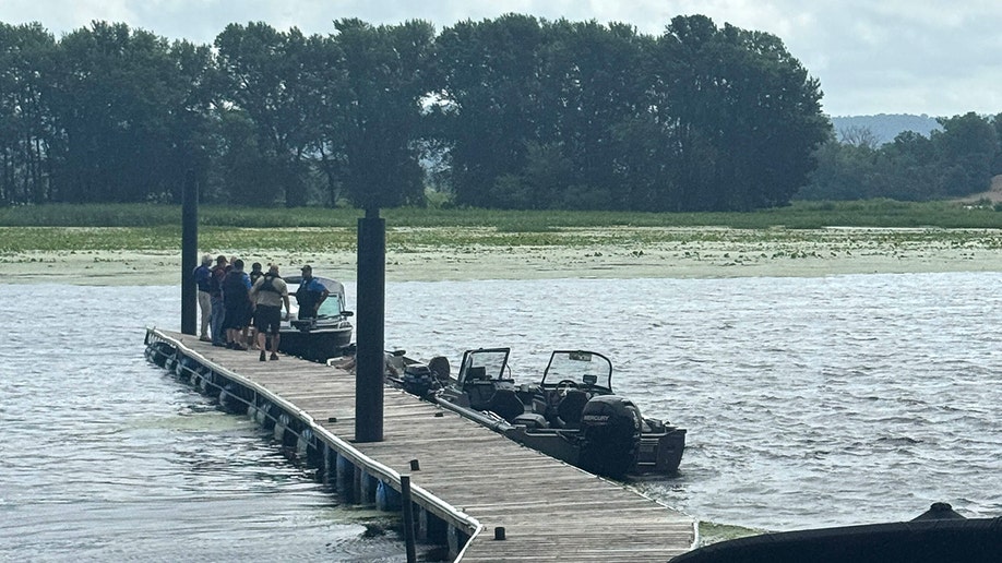 A photo taken by the marina bar owner's daughter shows first responders docked near the location Eliotte Heinz's body was found.