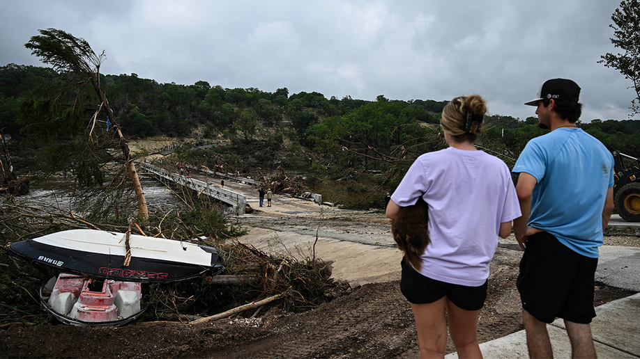 People look on as law enforcement and volunteers continue to search for missing people near Camp Mystic on July 5, 2025.
