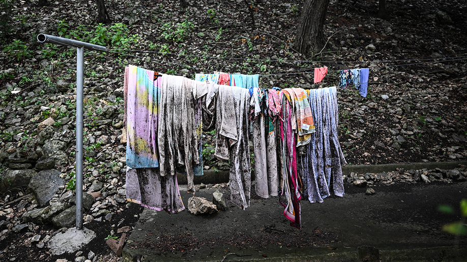 Towels and clothing hang on a clothesline outside of a cabin at Camp Mystic in Hunt, Texas, on July 5, 2025.