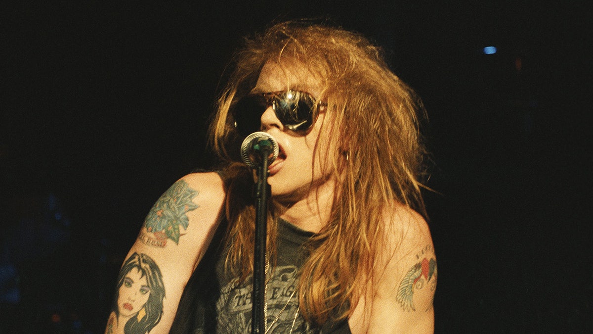 A close-up of Axl Rose singing on stage.