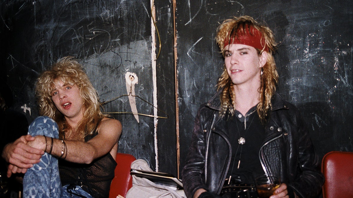 Steven Adler posing backstage after a concert and smiling.