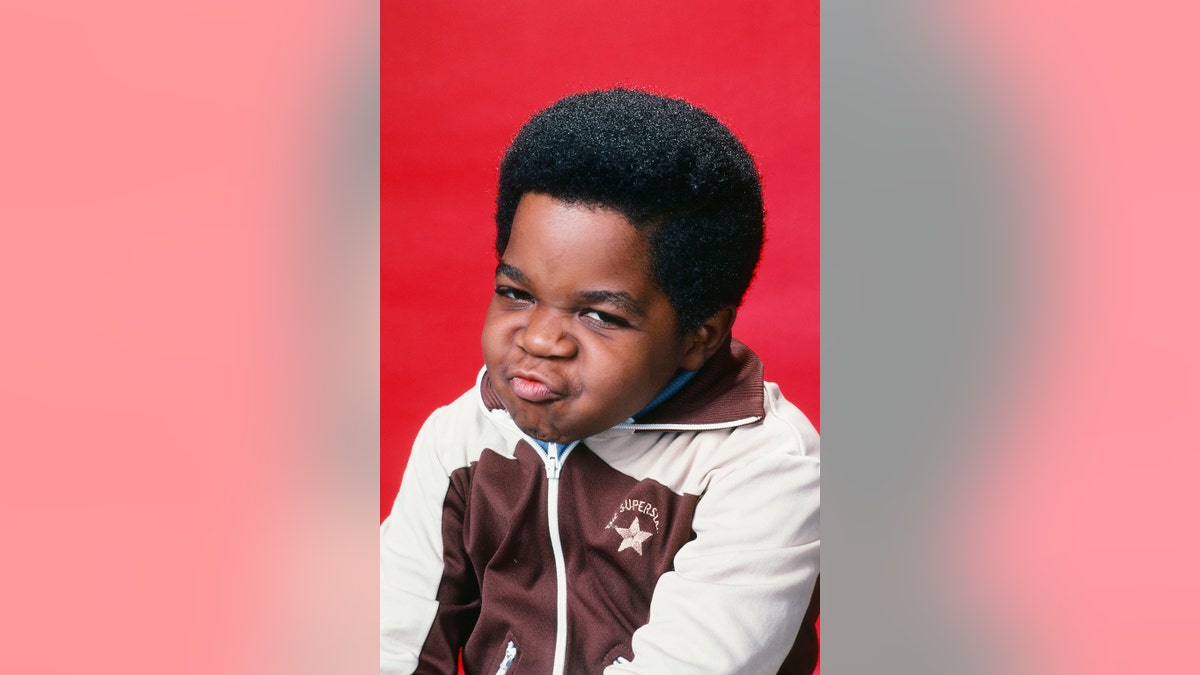 Gary Coleman making a funny face in a white and brown sweater.