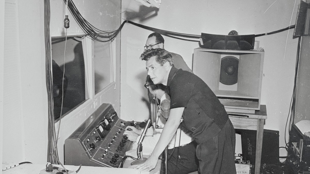 Desi Arnaz wearing all black working behind the scenes.