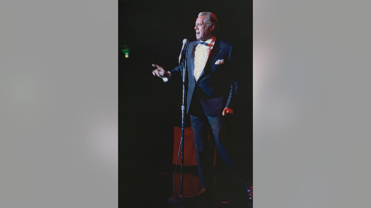 Desi Arnaz performing on stage in a suit.