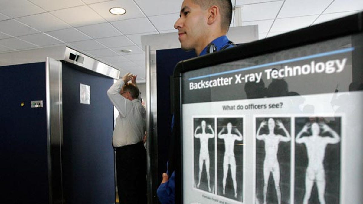 File: Transportation Security Administration employee Anthony Brock, left, demonstrates a new full-body scanner at San Diego's Lindbergh Field.