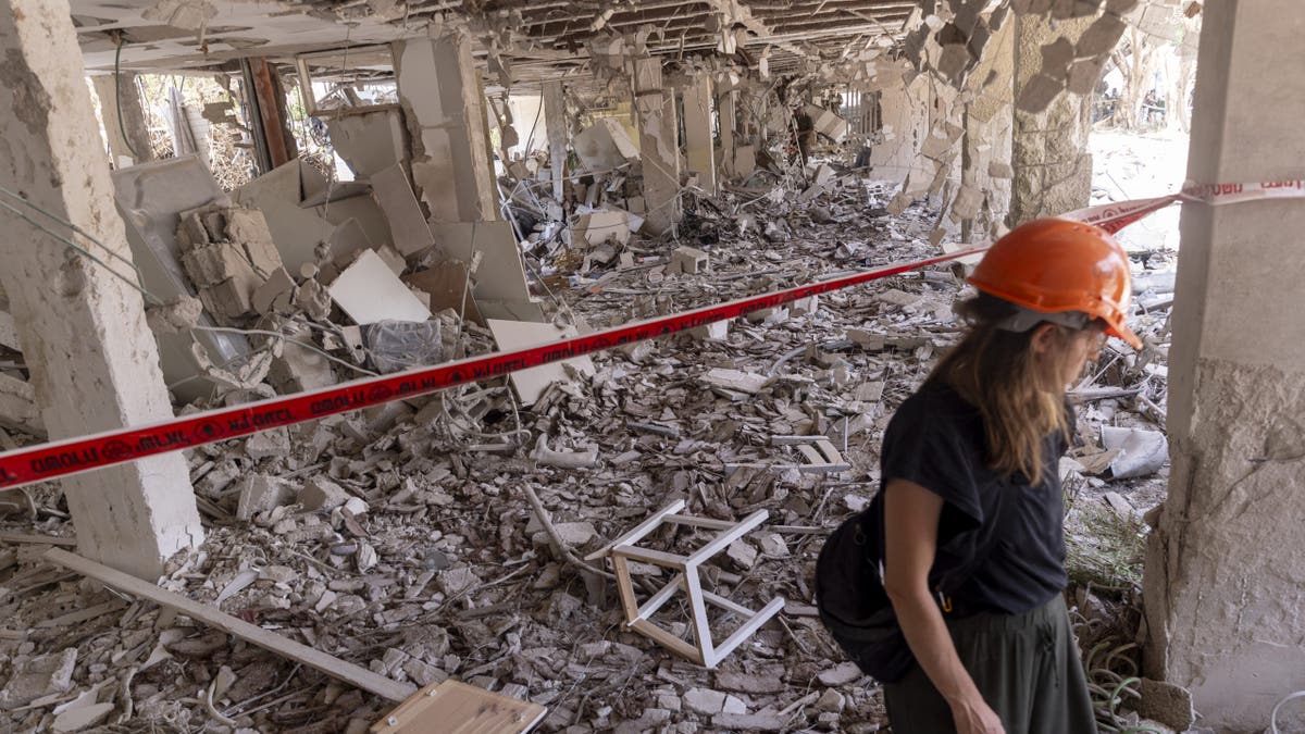 A woman retrieves personal belongings from the rubble of her house after a ballistic missile fired from Iran struck the city yesterday morning on June 23, 2025 in Tel Aviv, Israel. I