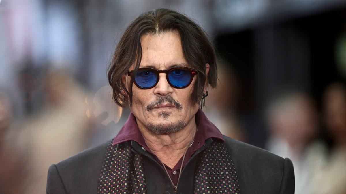 Johnny Depp attends a premiere wearing sunglasses