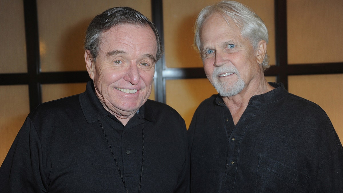 Jerry Mathers and Tony Dow both wearing black and smiling next to each other