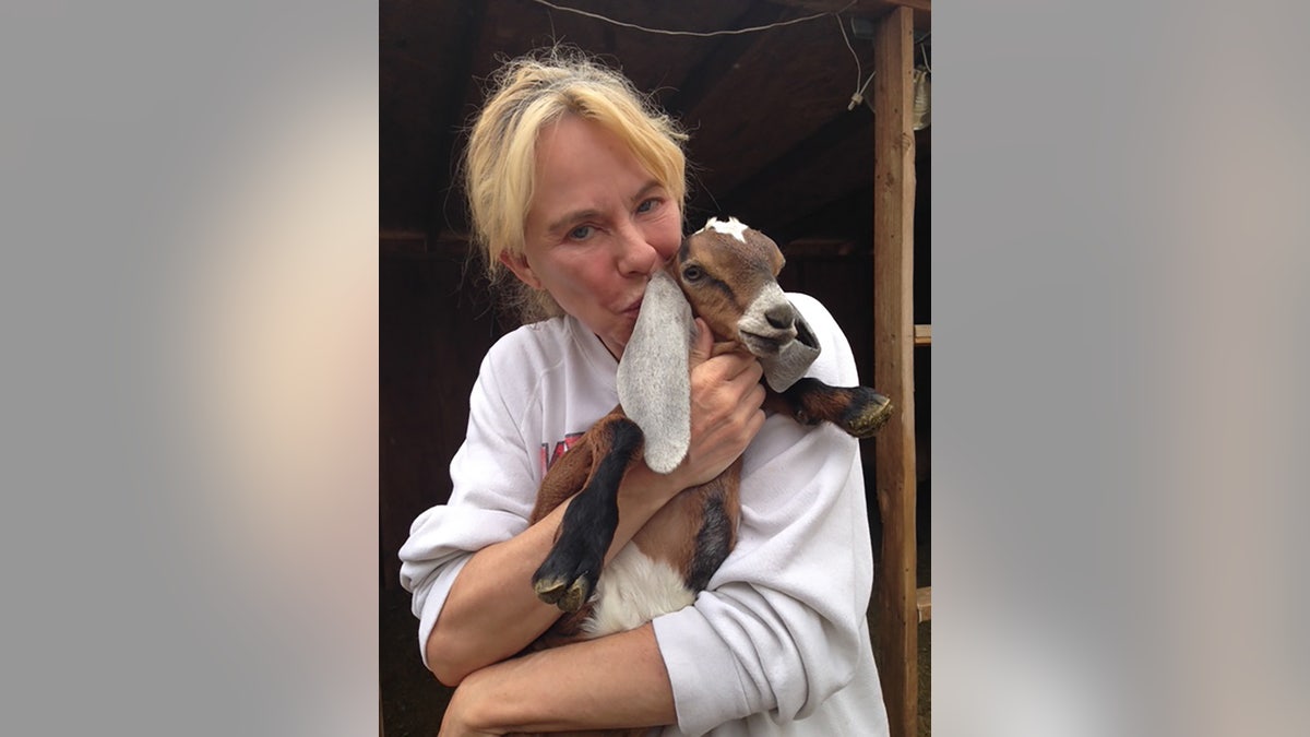 Jenilee Harrison holding a baby goat.