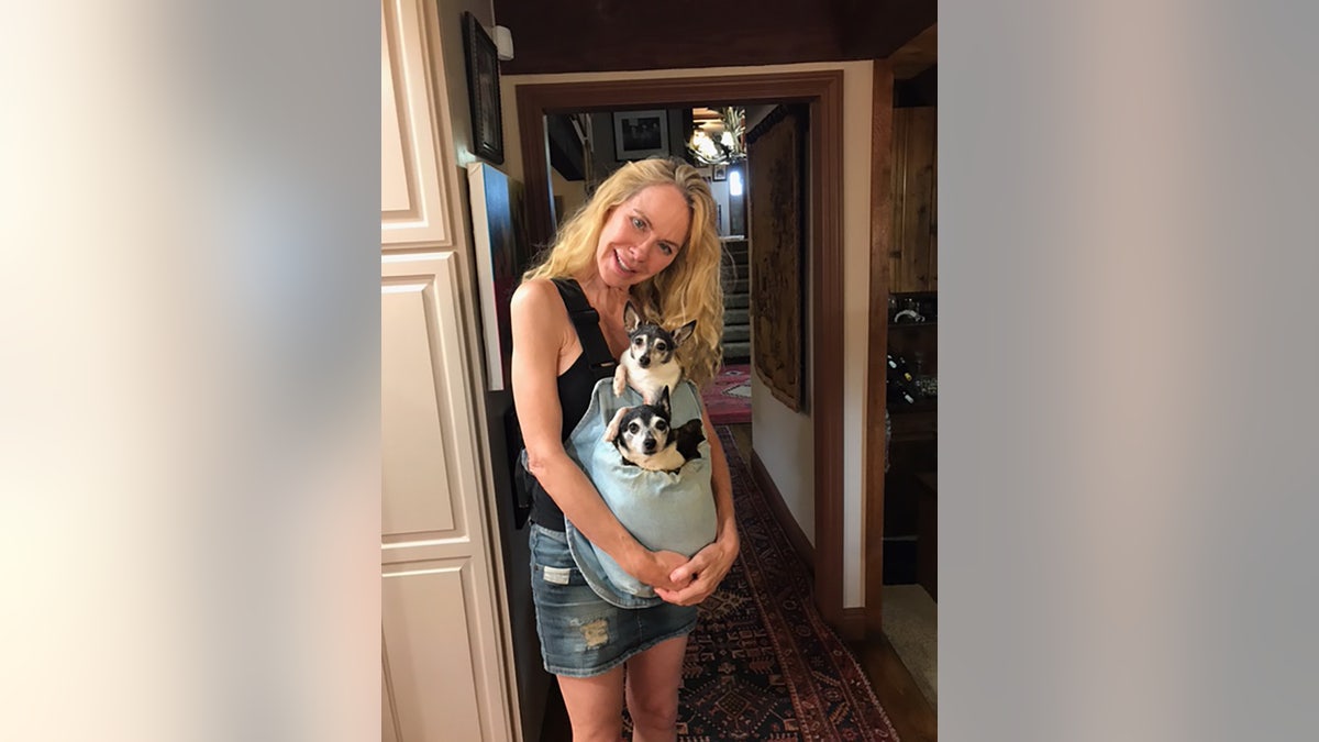 Jenilee Harrison holding two dogs.