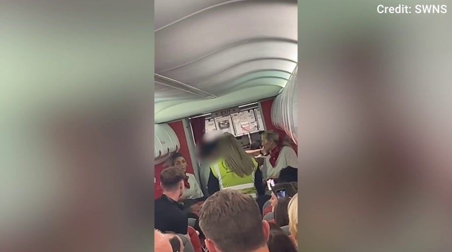 Officers escort two passengers off flight at UK airport