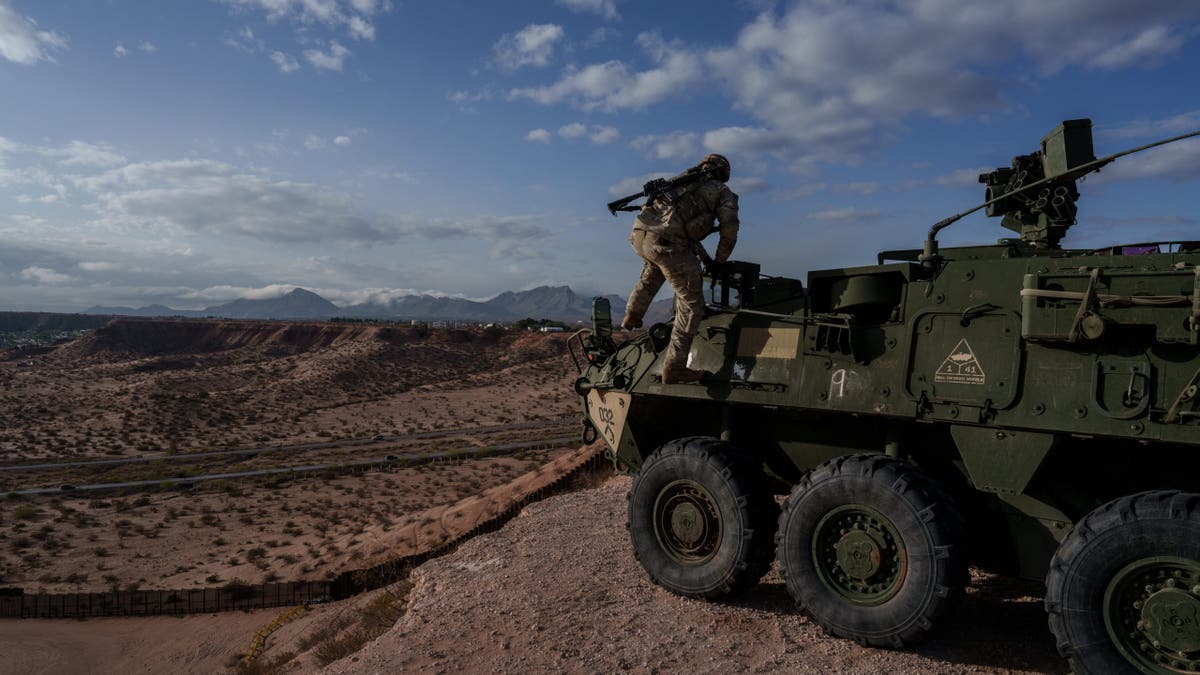 A U.S. Army soldier climbs down from the top of a Stryker armored infantry transport vehicle, which has been deployed along the U.S.-Mexico border as part of the military's Joint Task Force Southern Border mission, in Sunland Park, New Mexico on Friday, April 4, 2025.