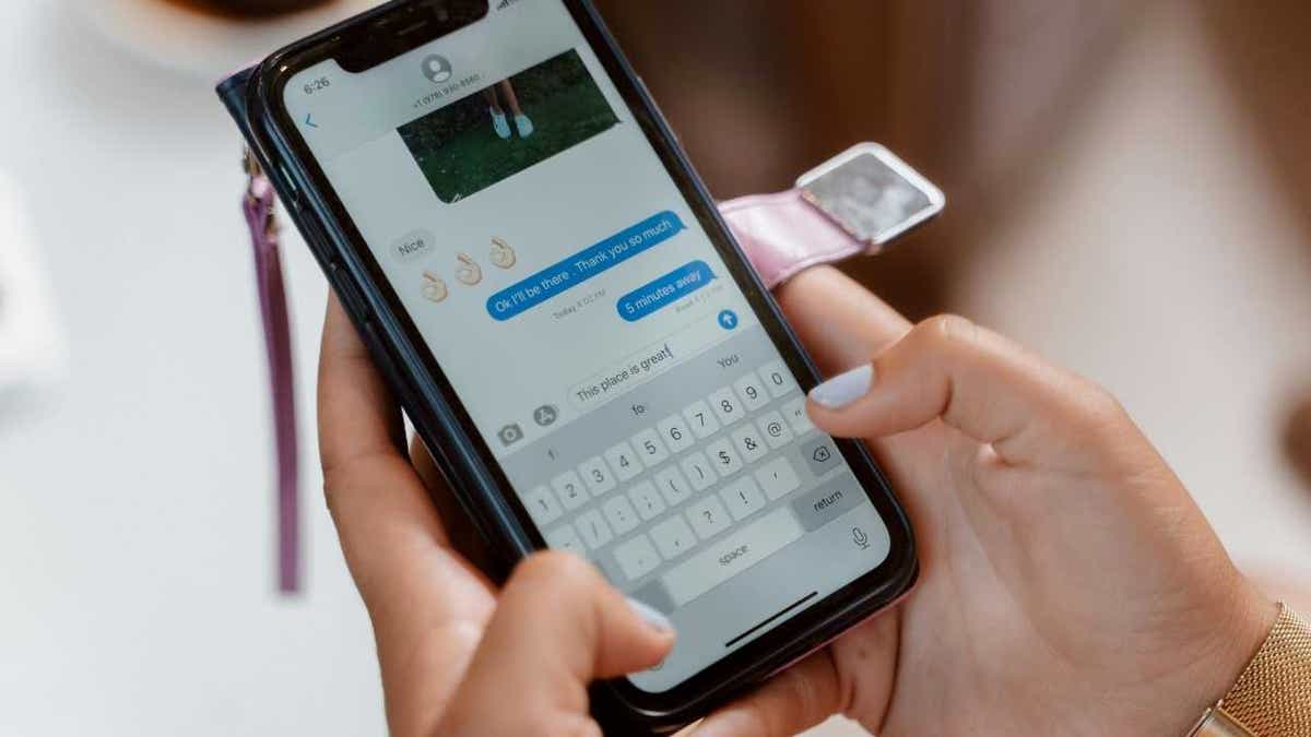 A woman using emojis in a text exchange with a frien.