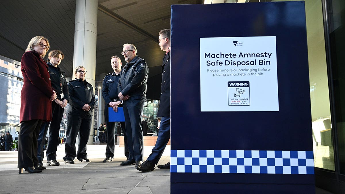Officials inspecting a Machete Amnesty Safety Disposal Bin