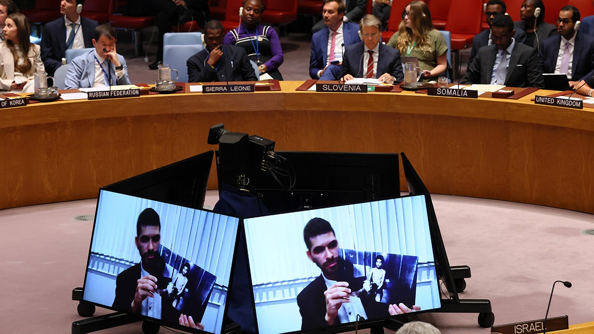 Members of the United Nations Security Council listen as Ilay David, brother of hostage Evyatar David, and holds up a photo of his brother in captivity as he speaks during a meeting called by Israel. 