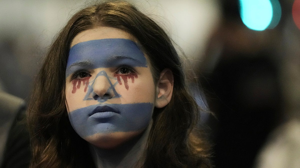 Woman wearing the colors of the Israeli flag on her face during a protest