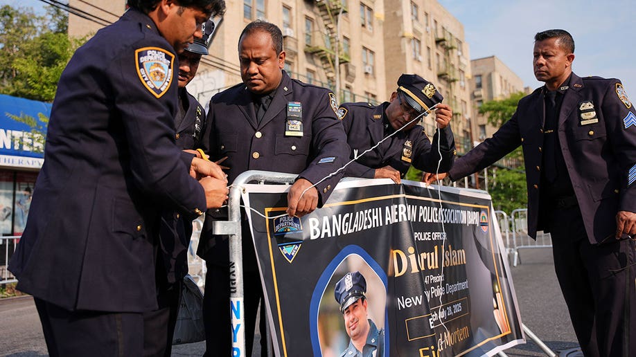 New York Police officers hang a banner