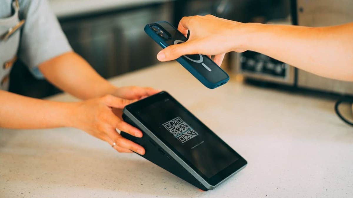 Woman uses phone to pay with QR code