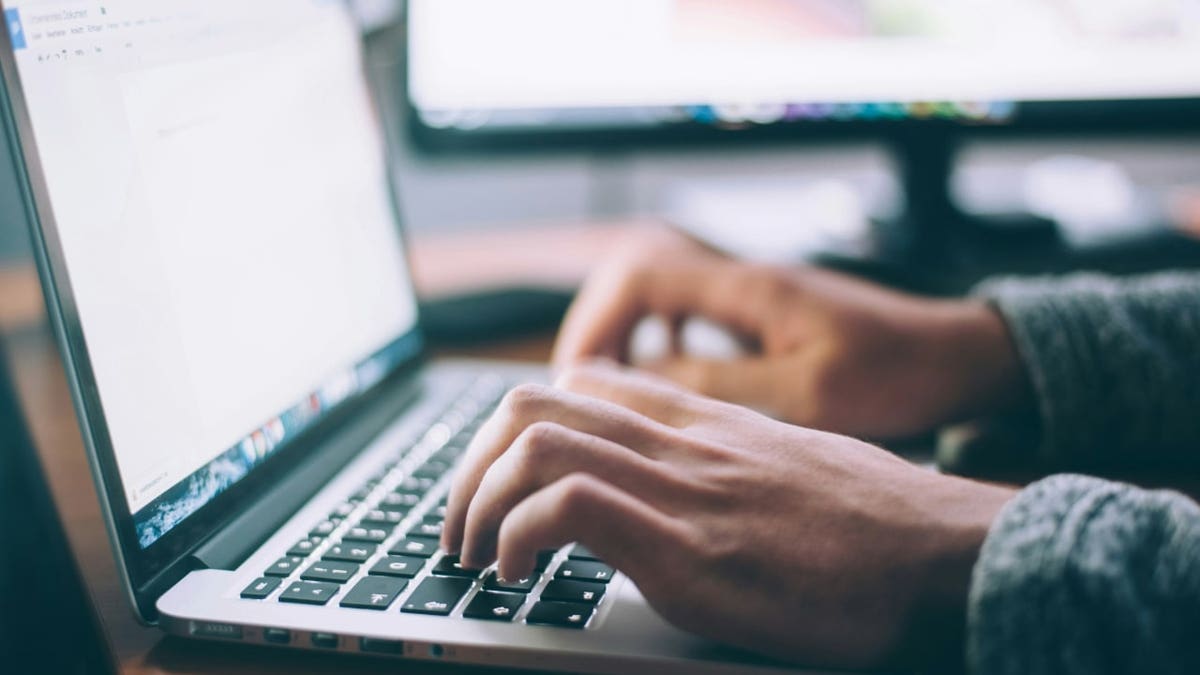 A person types on a computer.