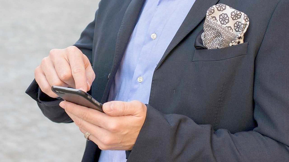 A man taps the screen of his smartphone.
