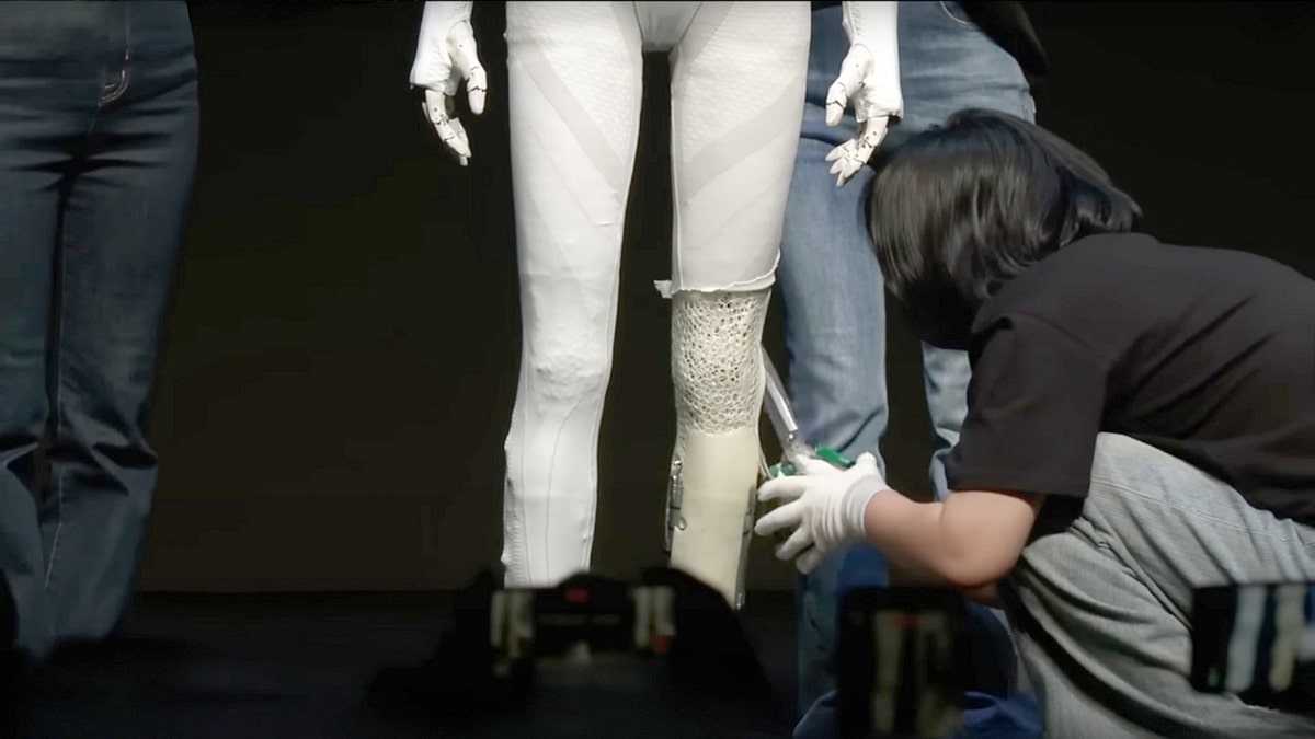 A person cutting open a robotic leg